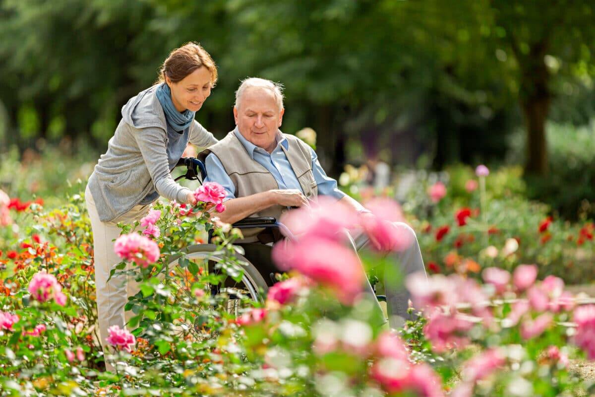 A Woman Pushing A Man In A Wheelchair