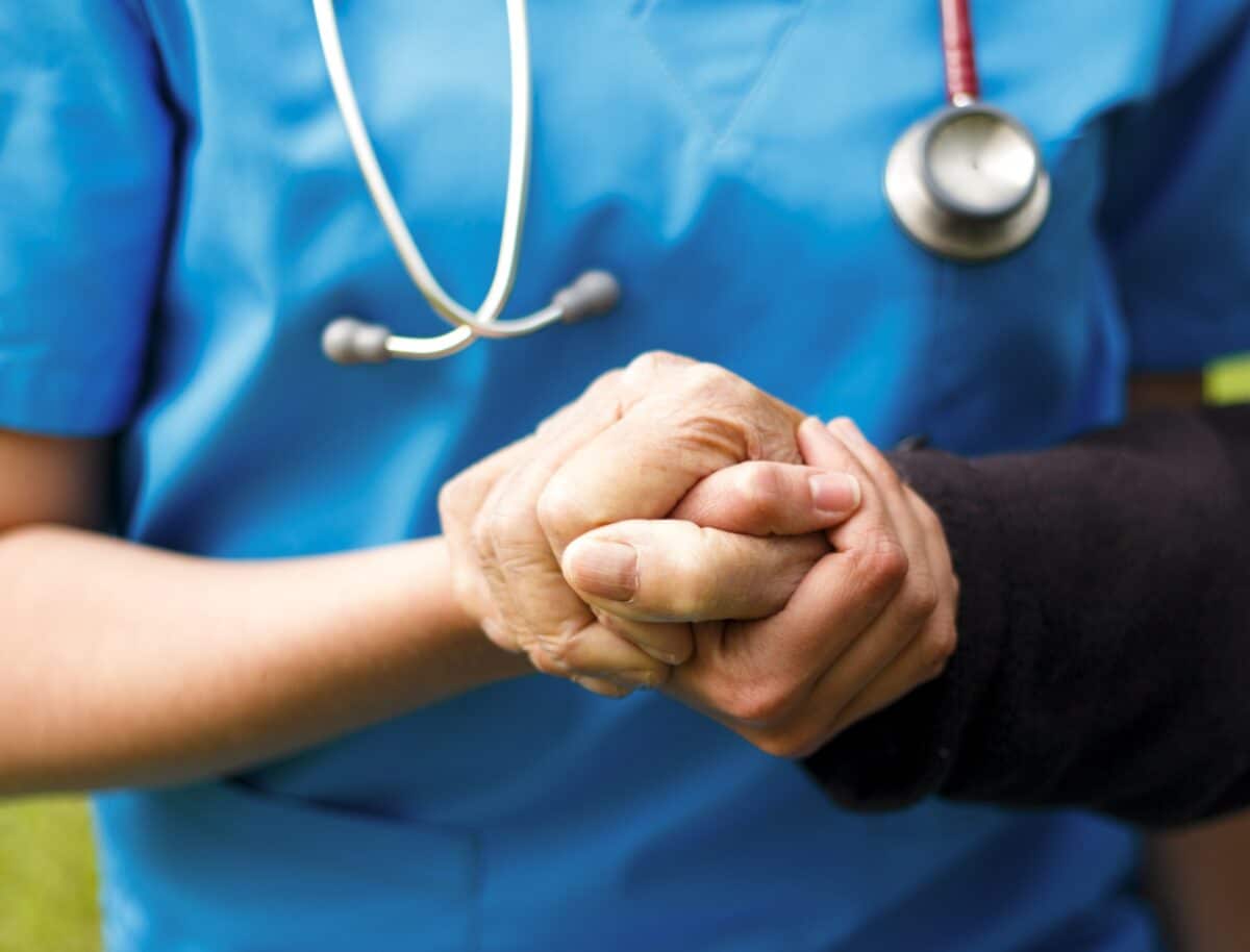 A Close-Up Of A Doctor Holding A Patient'S Hands
